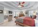 Spacious bedroom displaying a fireplace, tray ceiling, comfortable chairs, and decor, perfect for relaxation at 3520 Millwater Xing, Dacula, GA 30019