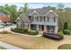 Traditional two-story home with manicured lawn, mature landscaping, and a welcoming front porch with seating at 3520 Millwater Xing, Dacula, GA 30019