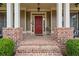 Inviting front porch with brick columns and cozy seating, perfect for enjoying a morning coffee or evening sunset at 3520 Millwater Xing, Dacula, GA 30019