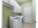 Efficient laundry room with front-load washer/dryer, tiled floor and ample storage space at 3520 Millwater Xing, Dacula, GA 30019