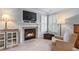 Cozy living room featuring a fireplace, television, comfortable chair, and natural light, ideal for relaxing at 3520 Millwater Xing, Dacula, GA 30019