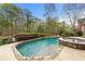 Backyard showcasing a stunning pool with an integrated spa and lush landscaping at 3520 Millwater Xing, Dacula, GA 30019