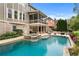 Backyard showcasing a stunning pool with an integrated spa and beautiful landscaping, with an upper deck at 3520 Millwater Xing, Dacula, GA 30019