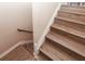 Interior staircase featuring wood-style steps and a white handrail at 1184 Red Oak Cv, Tucker, GA 30084