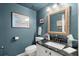 Stylish half-bath with granite countertop, framed mirror, and elegant fixtures at 2060 Clairmeade Ne Way, Atlanta, GA 30329