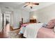 Bright bedroom featuring a cozy quilt, ceiling fan and a view into the home's hallway at 2060 Clairmeade Ne Way, Atlanta, GA 30329