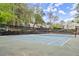 Community tennis court with a black net and fenced-in area surrounded by mature trees at 2060 Clairmeade Ne Way, Atlanta, GA 30329