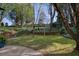 Landscaped backyard featuring a grassy lawn, mature trees, and a brick retaining wall at 2415 Carina Nw Ter, Acworth, GA 30101