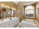 Bright bathroom featuring a soaking tub, double sinks, and a shower with modern fixtures at 2415 Carina Nw Ter, Acworth, GA 30101