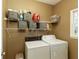Functional laundry room with washer, dryer, storage shelves, and natural light from the window at 2415 Carina Nw Ter, Acworth, GA 30101
