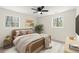 Cozy staged bedroom showcasing two windows, a bed with throw pillows and a ceiling fan at 6175 Knights Ln, Douglasville, GA 30135