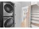 Laundry area with a stacked washer and dryer setup, hardwood floors, and access to the staircase at 699 Pryor Sw St # 4, Atlanta, GA 30315