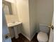 Cozy half bathroom featuring a pedestal sink, toilet, and mirror at 802 Crow View Ct, Woodstock, GA 30189