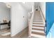 Bright entryway featuring a staircase with wood treads and an open door to a room with a desk at , Atlanta, GA 30315