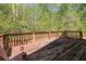 Exterior shot showcasing a wooden deck bordered with a red railing with nature background at 165 Gingercake Ct, Fayetteville, GA 30214