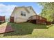 View of the home's exterior with a backyard deck surrounded by green grass and trees at 165 Gingercake Ct, Fayetteville, GA 30214
