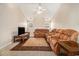 Inviting living room featuring plush, reclining sofa set, vaulted ceiling, and a cozy fireplace at 165 Gingercake Ct, Fayetteville, GA 30214