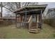 View of the backyard and covered porch, with dark wood trim and stairs at 1852 E Farris Ave, Atlanta, GA 30344