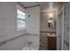 Neutral-toned bathroom featuring tiled walls with decorative border, vanity, and shower/tub combo at 1852 E Farris Ave, Atlanta, GA 30344