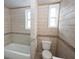 Modern bathroom featuring tiled walls, tub, and updated fixtures at 1852 E Farris Ave, Atlanta, GA 30344