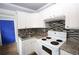 Kitchen featuring white cabinets, mosaic backsplash, tile floors, and stove appliance at 1852 E Farris Ave, Atlanta, GA 30344