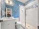 Charming bathroom featuring a glass enclosed shower, unique wallpaper, and vanity with white countertop at 803 Courtenay Ne Dr, Atlanta, GA 30306