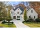 Charming two-story brick home with lush landscaping, mature trees, and a spacious driveway at 803 Courtenay Ne Dr, Atlanta, GA 30306