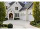 Elegant brick home featuring a two-car garage, arched doorway, and manicured landscaping at 803 Courtenay Ne Dr, Atlanta, GA 30306