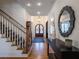 Elegant foyer featuring hardwood floors, a staircase, and stylish console table with mirror at 803 Courtenay Ne Dr, Atlanta, GA 30306