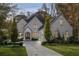 Charming white brick home featuring manicured landscaping and a paved driveway leading to an attached garage at 803 Courtenay Ne Dr, Atlanta, GA 30306
