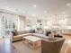Bright, open living room with hardwood floors, large sectional, and seamless flow to a modern, white kitchen at 803 Courtenay Ne Dr, Atlanta, GA 30306