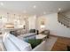 Spacious living room with hardwood floors, modern sectional, and staircase leading to the upper level at 803 Courtenay Ne Dr, Atlanta, GA 30306
