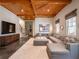 Inviting living room with wood-paneled ceiling, large sectional sofa, and expansive rug, perfect for relaxation and entertainment at 803 Courtenay Ne Dr, Atlanta, GA 30306