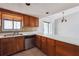 Bright kitchen area with window, wooden cabinets, stainless steel dishwasher, and tile floor at 404 Willow Way, Villa Rica, GA 30180