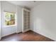 Cozy bedroom with hardwood floors, a built-in bookshelf, and a window providing natural light and green views at 460 Laurel Chase Ct, Atlanta, GA 30327