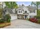 Elegant home with a manicured lawn, stone accents, multi-car garage, and a welcoming entrance at 460 Laurel Chase Ct, Atlanta, GA 30327