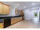 Bright kitchen with light wood cabinets, black countertops, stainless steel appliances, and a view to the next room at 460 Laurel Chase Ct, Atlanta, GA 30327