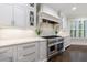 Chef's kitchen with custom range hood, stainless steel appliances, and sleek countertops at 460 Laurel Chase Ct, Atlanta, GA 30327