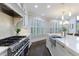 Gourmet kitchen featuring stainless steel appliances, white cabinetry, and bright windows at 460 Laurel Chase Ct, Atlanta, GA 30327