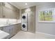 Well-organized laundry room featuring custom cabinets, sink, and stacked washer and dryer at 460 Laurel Chase Ct, Atlanta, GA 30327