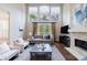 Bright living room boasts soaring windows, fireplace, hardwood floors, and modern furnishings at 460 Laurel Chase Ct, Atlanta, GA 30327