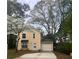 Charming two-story home with a light yellow exterior, attached garage and driveway, surrounded by beautiful trees at 5331 Ridge Forest Dr, Stone Mountain, GA 30083