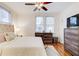 A furnished bedroom with hardwood floors, natural light, a ceiling fan, and simple decor at 733 Frederica Ne St # 12, Atlanta, GA 30306