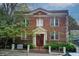 Charming two-story brick building featuring symmetric design, a red door, and manicured greenery at 733 Frederica Ne St # 12, Atlanta, GA 30306