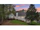 View of the home's backyard featuring a deck, lush lawn, and mature trees providing shade and privacy at 740 Trillium Ln, Lilburn, GA 30047