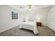 Cozy bedroom with plush gray carpet, window, and stylish ceiling fan with light fixture at 740 Trillium Ln, Lilburn, GA 30047