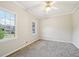 Bedroom featuring plush gray carpet, large windows, and stylish ceiling fan with light fixture at 740 Trillium Ln, Lilburn, GA 30047