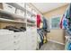 Walk-in closet featuring custom white shelving, ample storage, and natural light from a window at 740 Trillium Ln, Lilburn, GA 30047