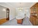 Dining room with natural light, chandelier, wooden hutch, and gray carpet at 740 Trillium Ln, Lilburn, GA 30047