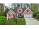 Beautiful two-story red brick home features a well-maintained lawn and an attached two-car garage at 740 Trillium Ln, Lilburn, GA 30047